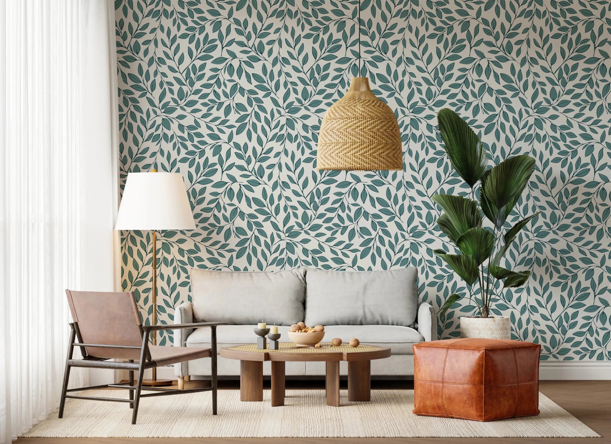 Teal Vines wallpaper with teal foliage behind a grey sofa, leather sling chair and fan palm in a living room