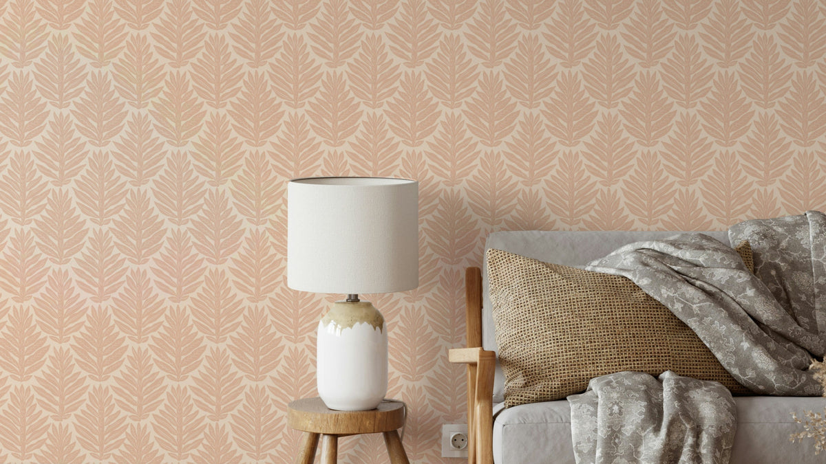 Terracotta Leaf Scallop Jewel Jungle wallpaper in a living room behind a grey sofa with a white lamp on a wood stool