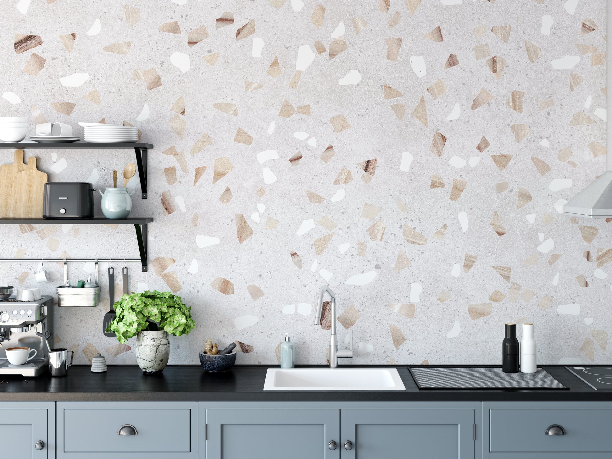 Terrazzo Marble Tile wallpaper mural in cream as a kitchen backsplash above a black counter and blue-grey cabinets