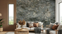 Textured Rock wallpaper mural in grey stone behind a rattan sofa with boho pillows and pampas grass by a slat wall