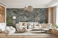 Textured Rock wallpaper mural in grey stone behind a cream sofa with woven pendants and built-in shelving