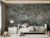 Textured Rock wallpaper mural in grey-green stone behind a white toddler bed with toys in a child's bedroom