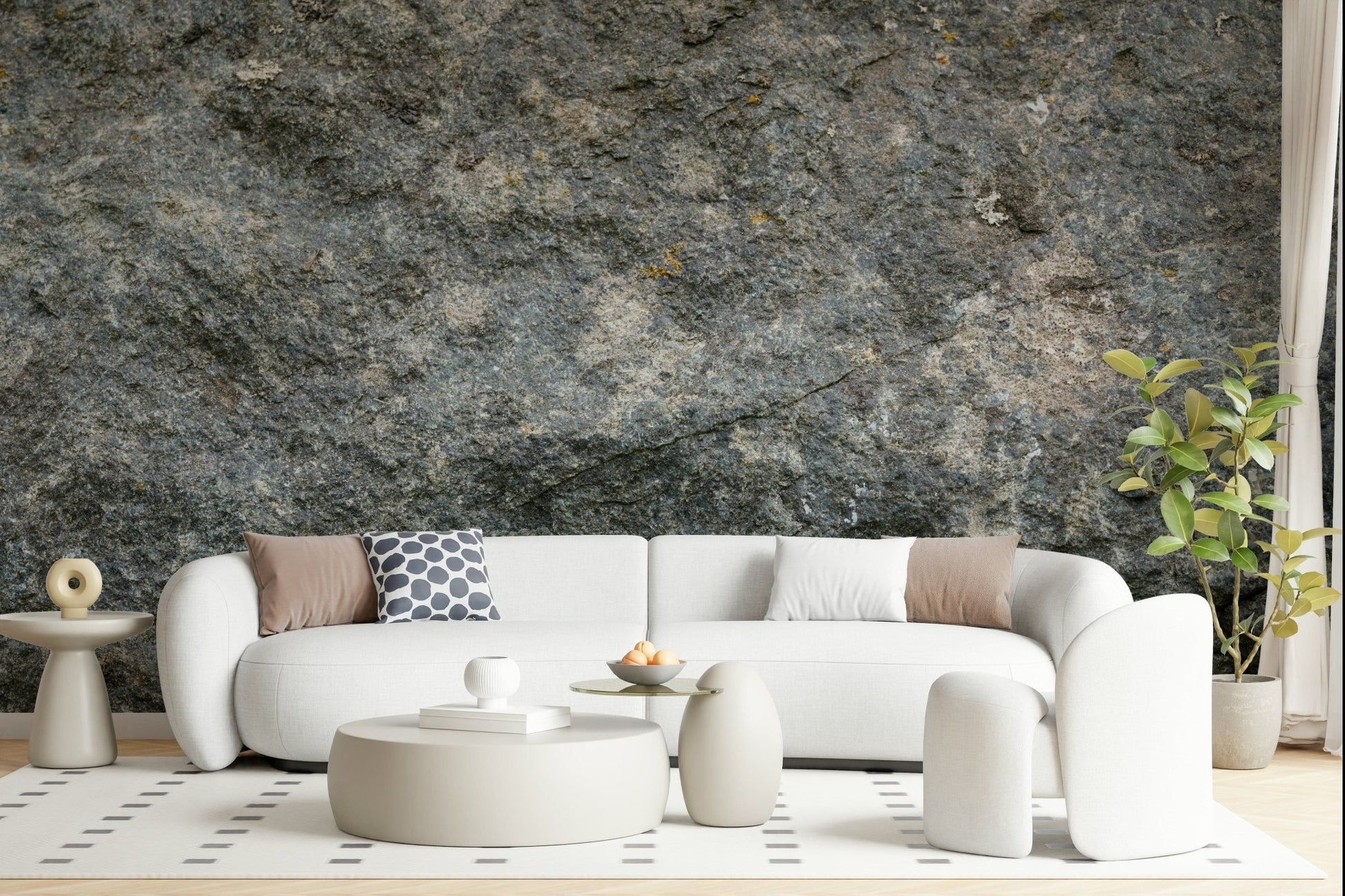 Textured Rock wallpaper mural in grey-green stone behind a curved white sofa and round beige coffee tables