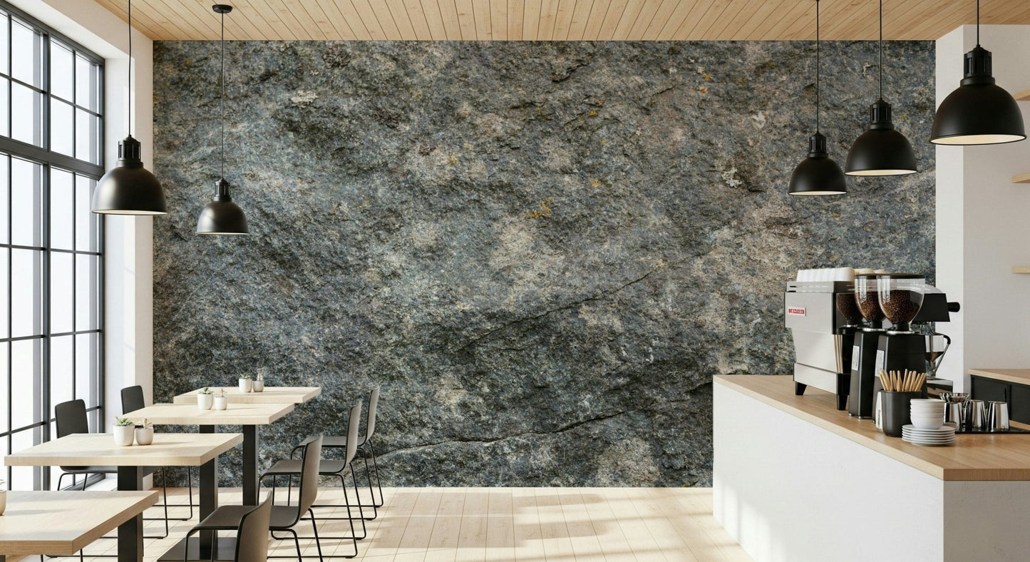 Textured Rock wallpaper mural in grey stone in a cafe with wood tables, black pendant lamps and an espresso machine