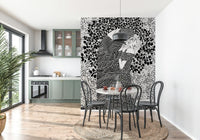 The Kiss II wallpaper mural of a monochrome embracing couple behind a marble bistro table and black chairs