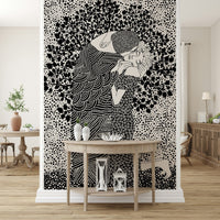 The Kiss II wallpaper mural of an embracing couple in black and white behind a wood demilune console table