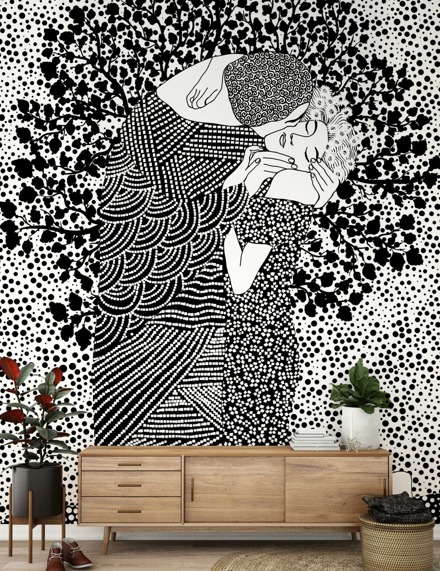 The Kiss II wallpaper mural of a black and white embracing couple above a wood credenza with plants