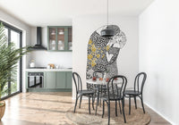 The Kiss wallpaper mural behind a terrazzo table and black bentwood chairs by a green kitchen