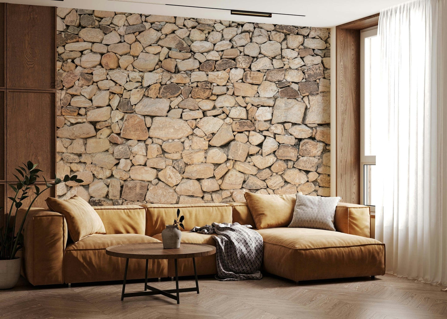 Timeless Stonework wallpaper mural of tan fieldstone behind a mustard velvet sectional sofa in a warm living room