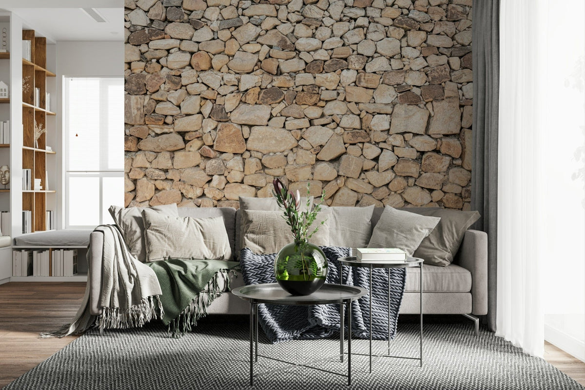 Timeless Stonework wallpaper mural of tan fieldstone behind a beige sofa with a sage throw and protea in a living room