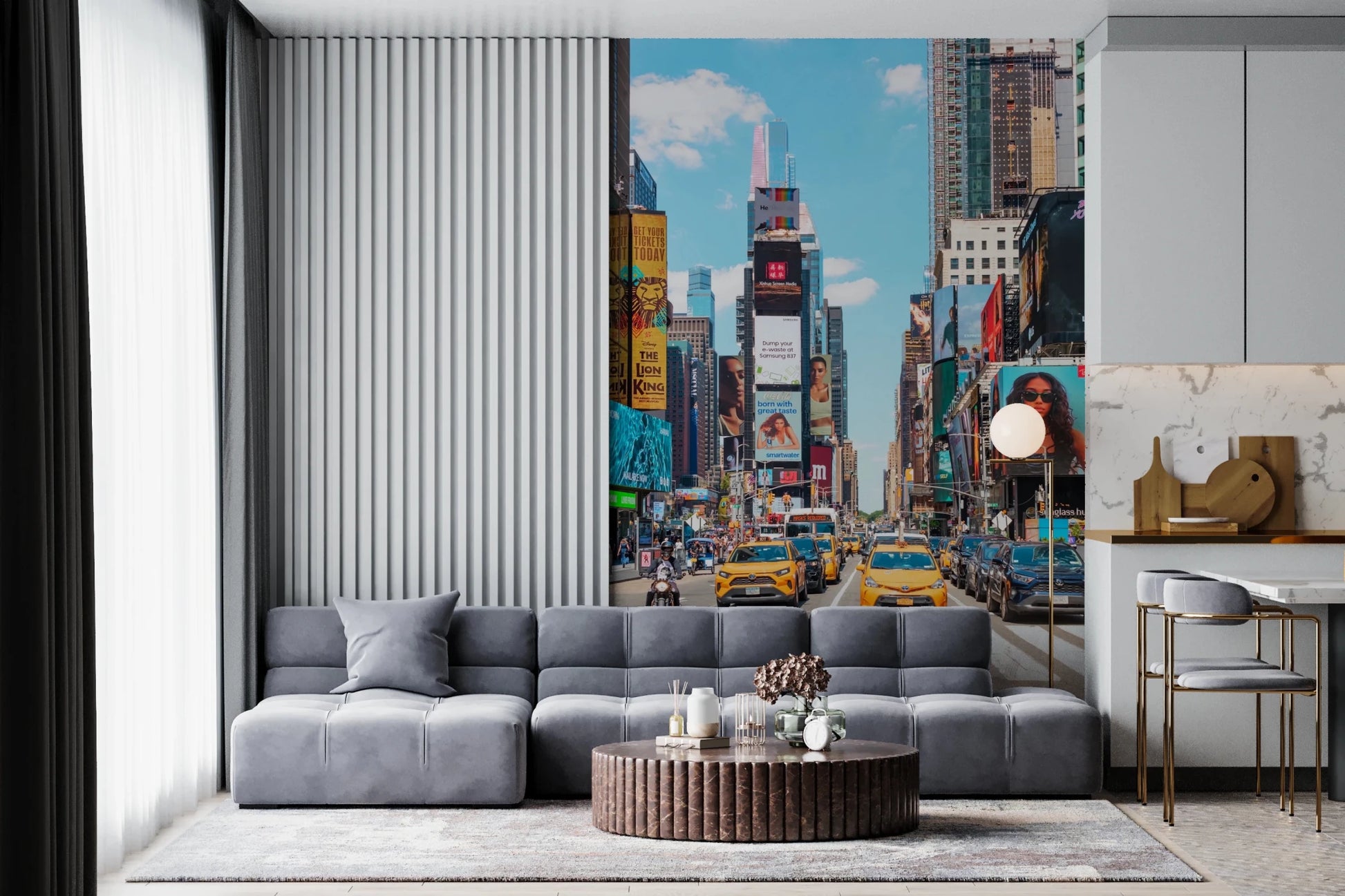 Times Square Buzz wallpaper mural of NYC taxis and billboards behind a gray modular sofa and fluted round table