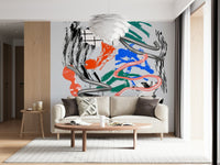 Tornado wall mural with chrome ribbons over orange, blue and green strokes behind a beige sofa and pendant light