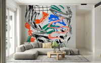 Tornado wall mural with chrome swirls and pink ribbon over colorful brushstrokes behind a gray sectional sofa in a living room