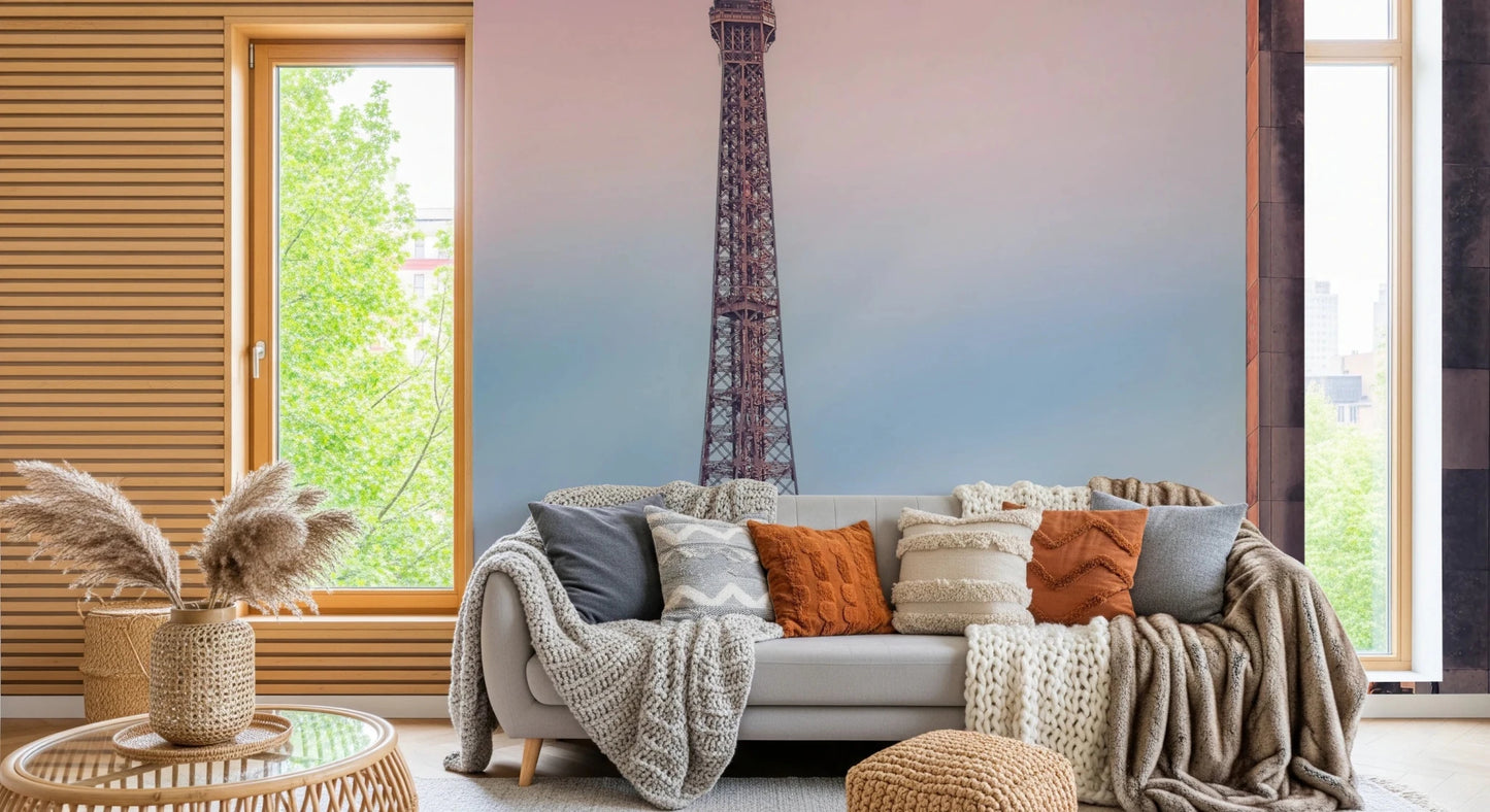 Tour Eiffel Sunset wallpaper mural of the Eiffel Tower behind a grey sofa with knit and rust cushions