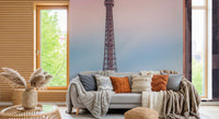 Tour Eiffel Sunset wallpaper mural of the Eiffel Tower behind a grey sofa with knit and rust cushions