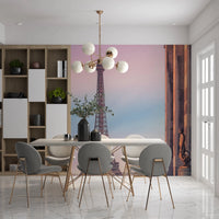 Tour Eiffel Sunset wallpaper mural of the tower against pastel sky in a dining room with grey chairs and gold chandelier