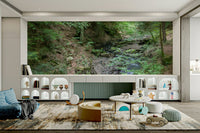 Gentle forest stream flowing through vibrant green foliage on a wall.

