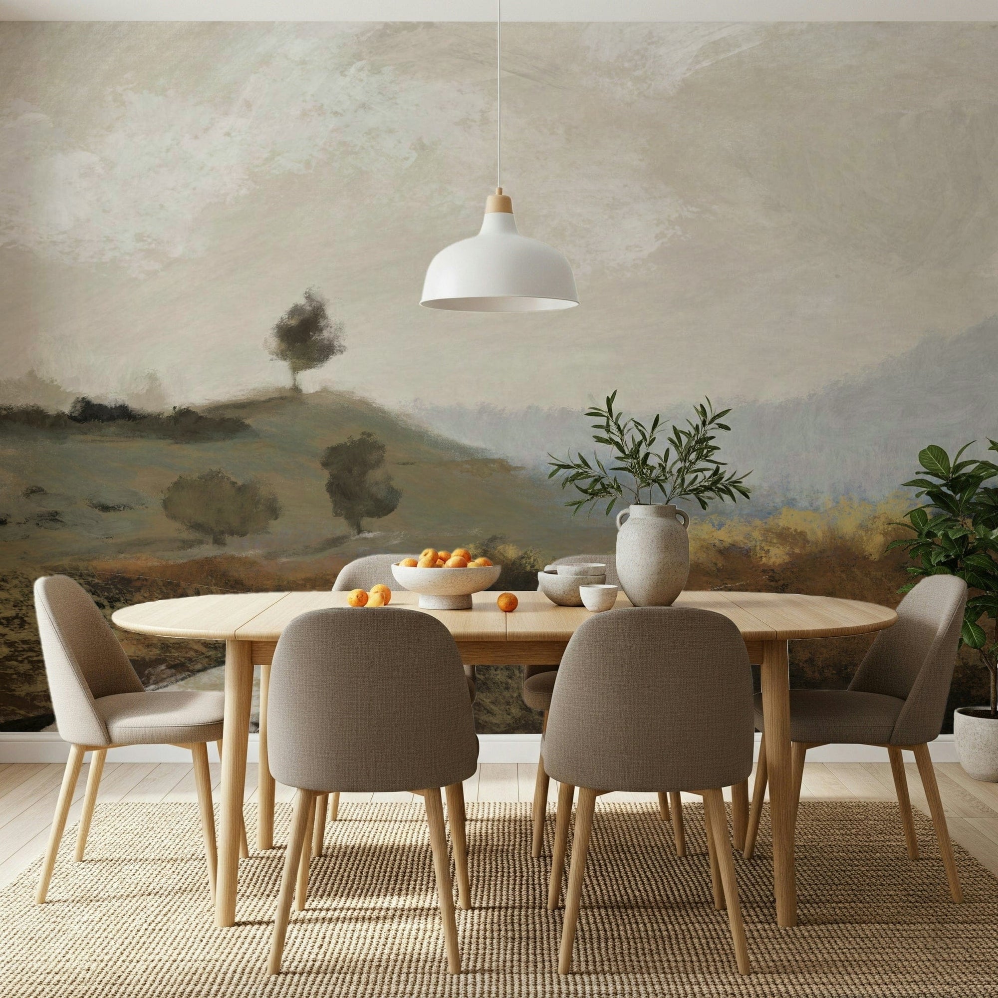 Painted Vista wallpaper mural of a lone tree on a hill behind a wood dining table and taupe chairs