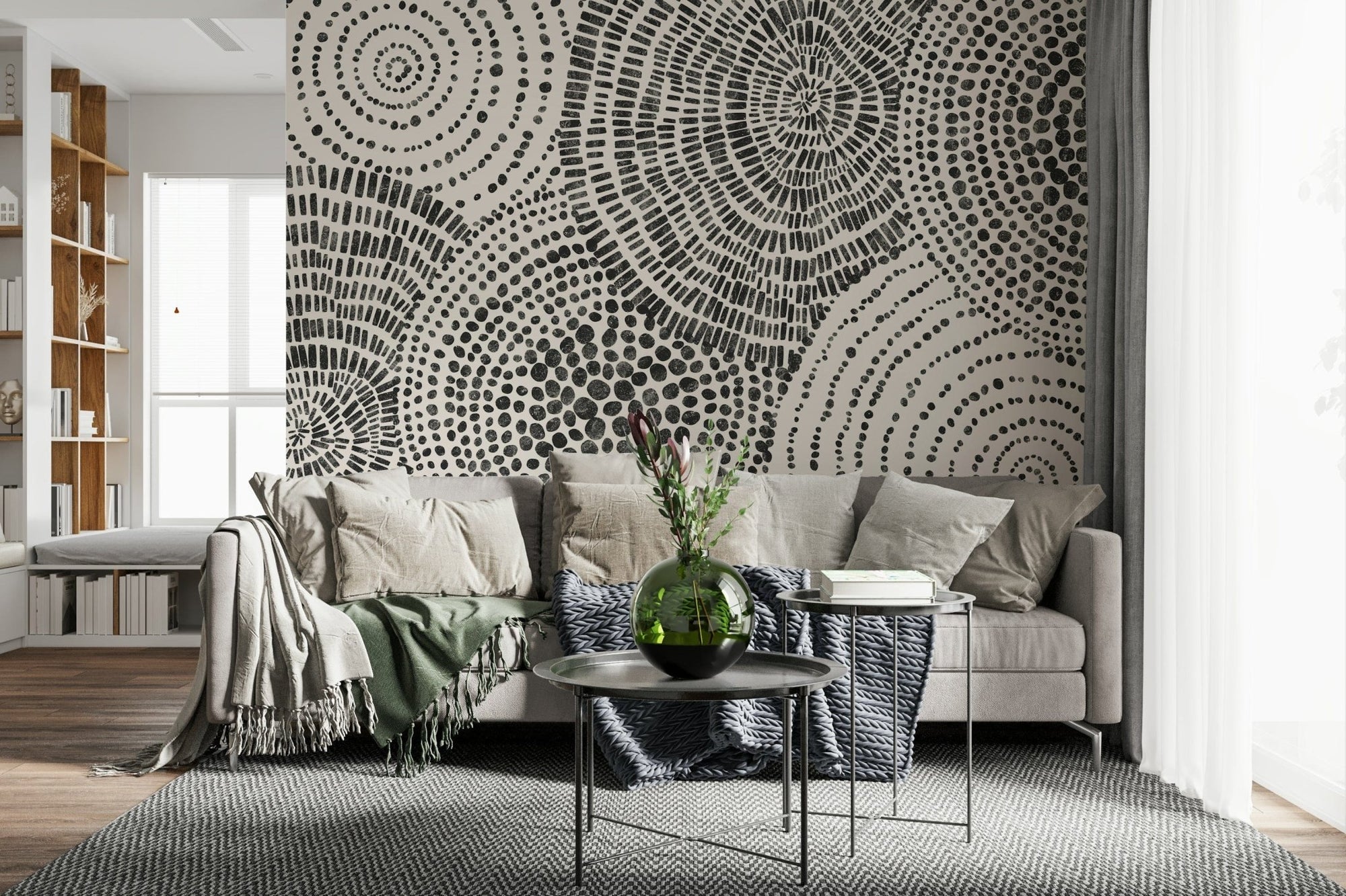 Tribal Rhythms wallpaper mural of black dotted circles behind a beige sofa with green throws in a lounge