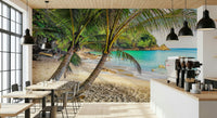 Tropical Beach Escape wallpaper mural of palms over a sandy cove in a cafe with black pendants and an espresso machine