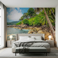 Tropical Shores wallpaper mural of a palm coast and turquoise sea above an upholstered bed in a calm bedroom