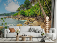 Tropical Shores wallpaper mural showing a rocky tropical bay behind a white sofa and tan armchair in a living room