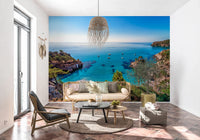 Turquoise Cove Escape wallpaper mural with turquoise water behind a cane sofa in a tiled living room