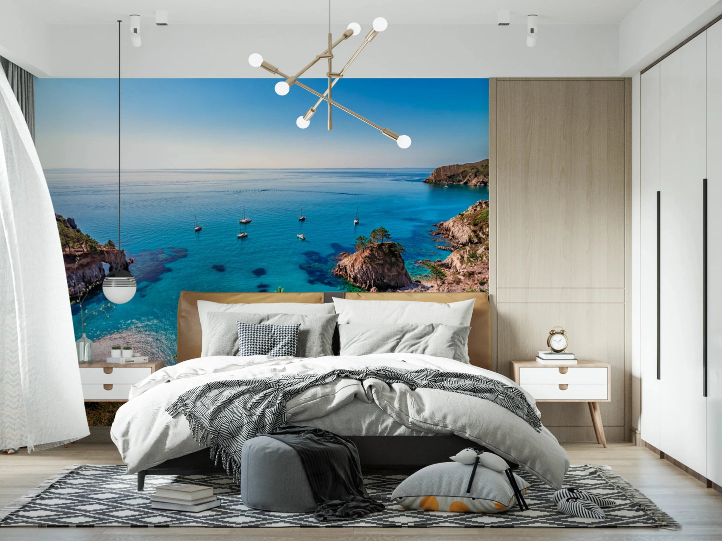 Turquoise Cove Escape wallpaper mural with sailboats behind a bed with grey bedding and sputnik chandelier