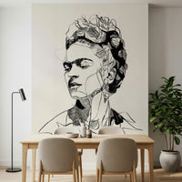 Unbroken wallpaper mural with a black line portrait above a wood dining table and beige chairs