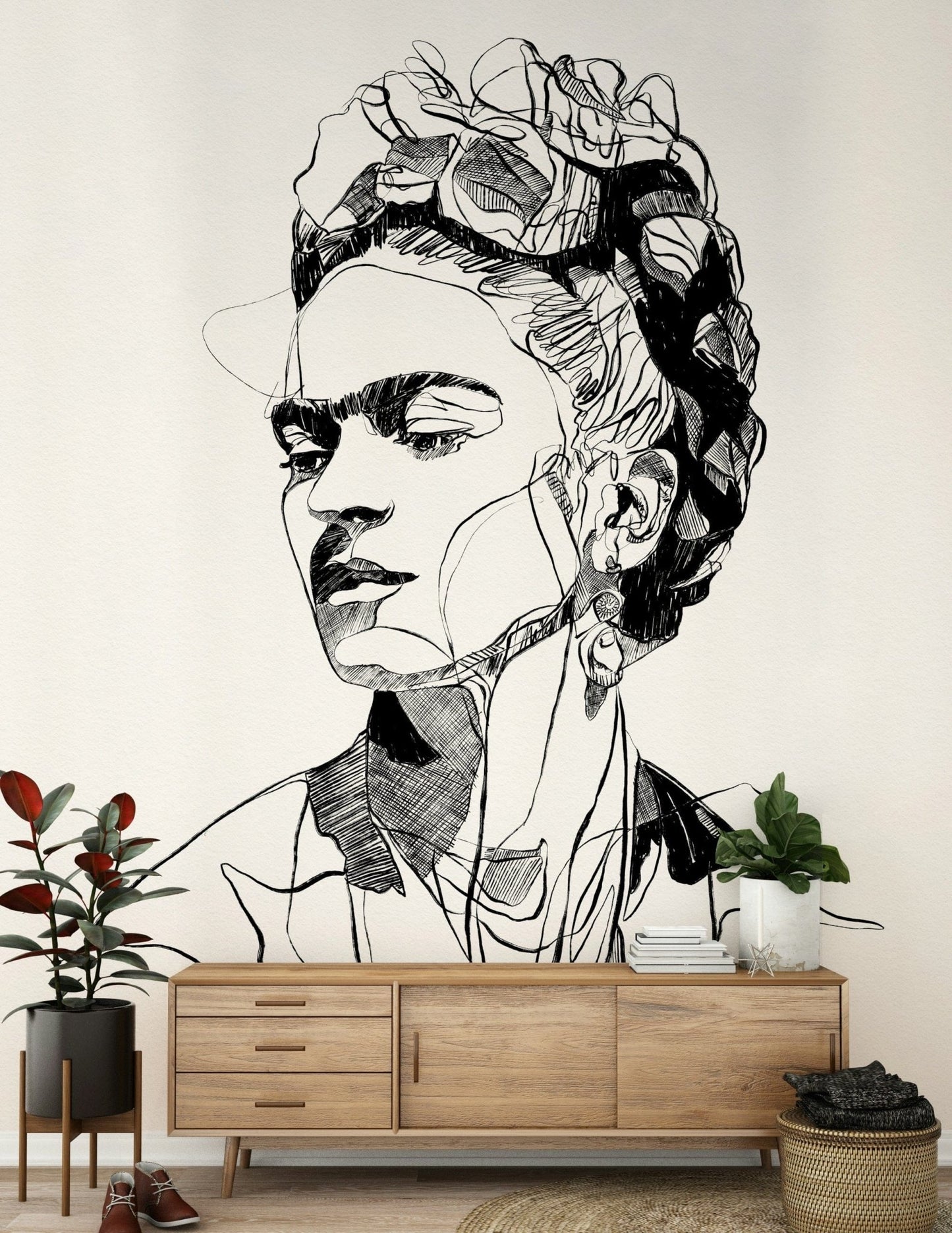 Unbroken wallpaper mural of a line-drawn woman's face above a wood sideboard with plants in an entryway