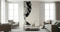 Unbroken wallpaper mural showing a cropped sketched face on cream behind gray armchairs and a glass coffee table