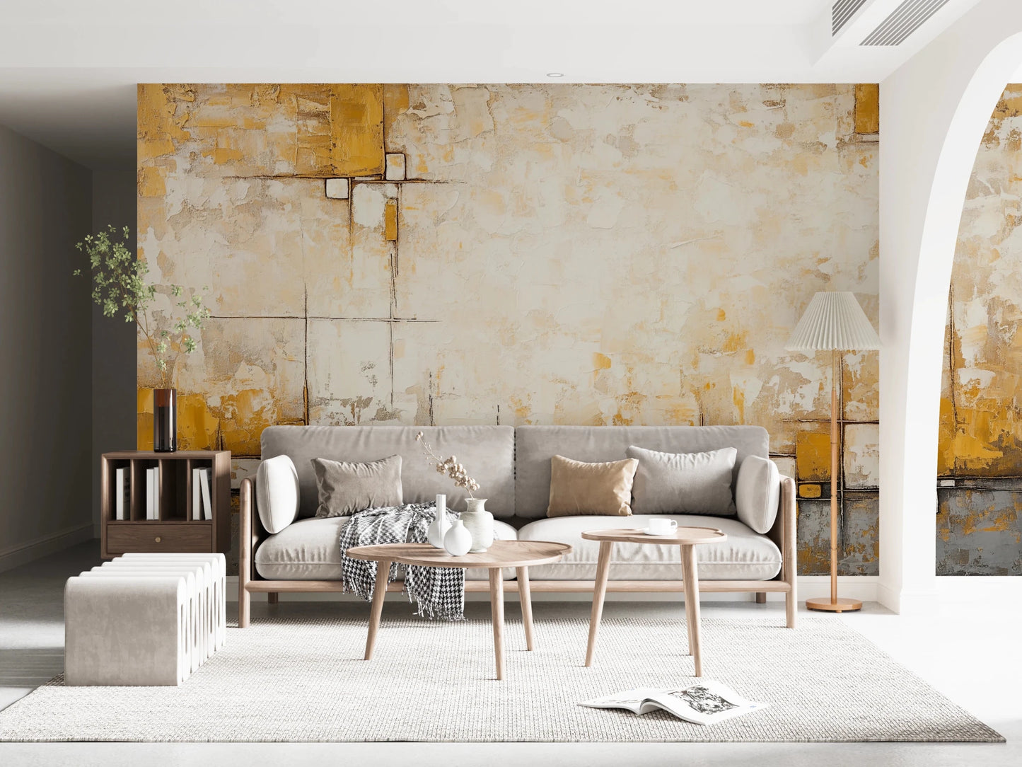 Urban Blocks wallpaper mural with gold and cream plaster blocks behind a grey sofa and wood side tables in a living room