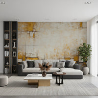Urban Blocks wallpaper mural with mustard and cream textured geometric blocks behind a two-tone grey sectional in a living room