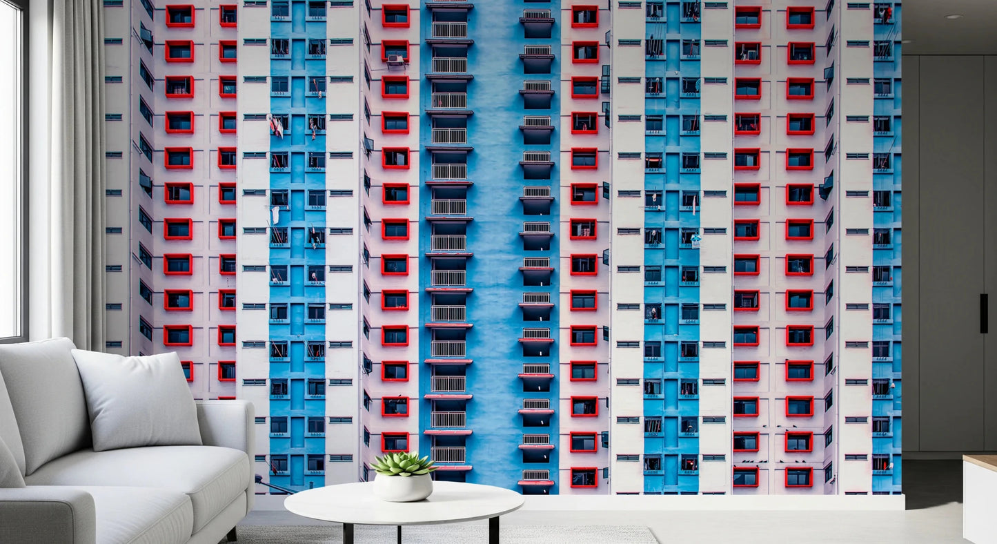Urban Gridlock wallpaper mural of red and blue high-rise windows behind a white sofa in a modern living room