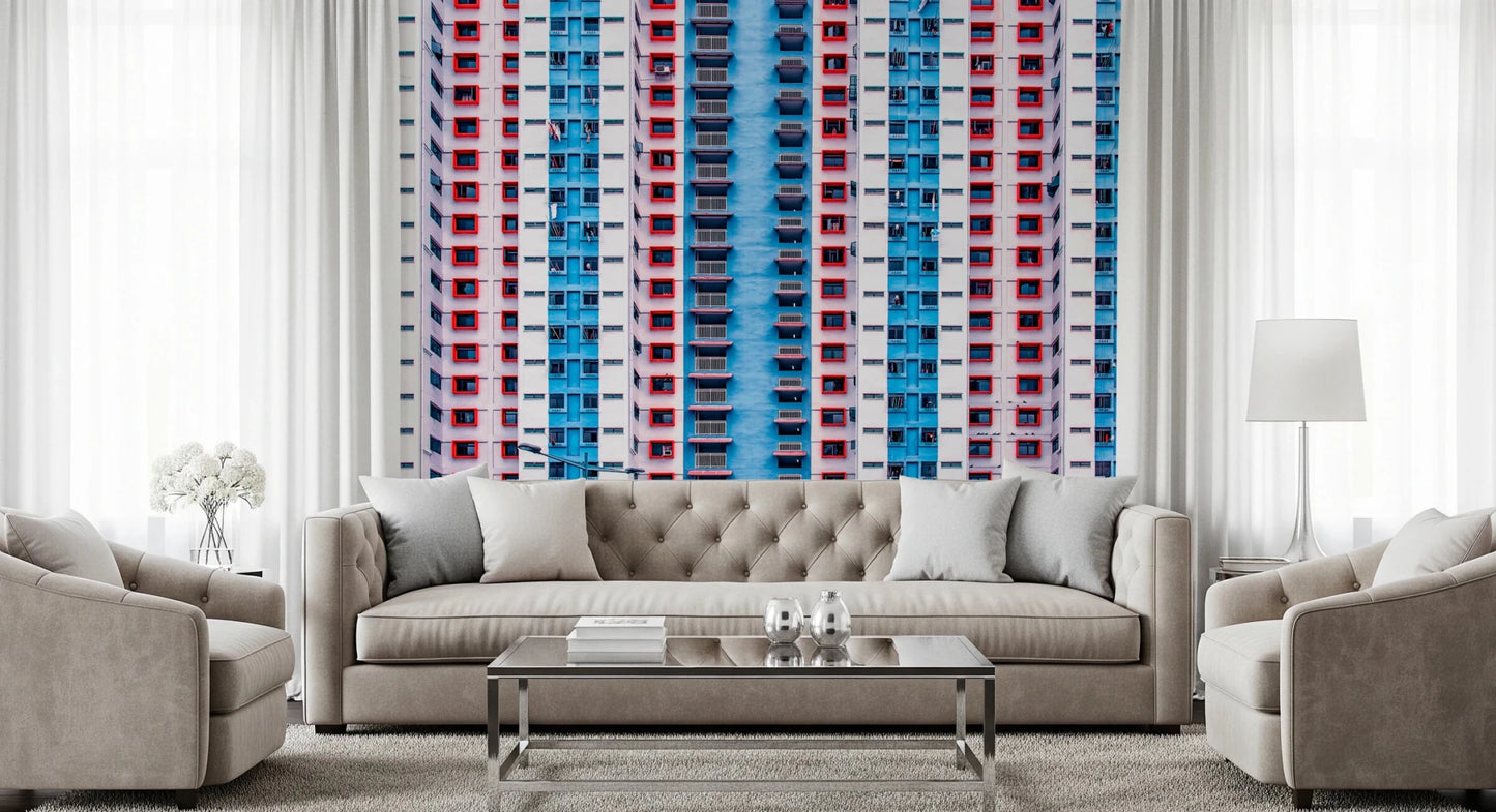 Urban Gridlock wallpaper mural of red and blue tower windows behind a tufted beige sofa and armchairs