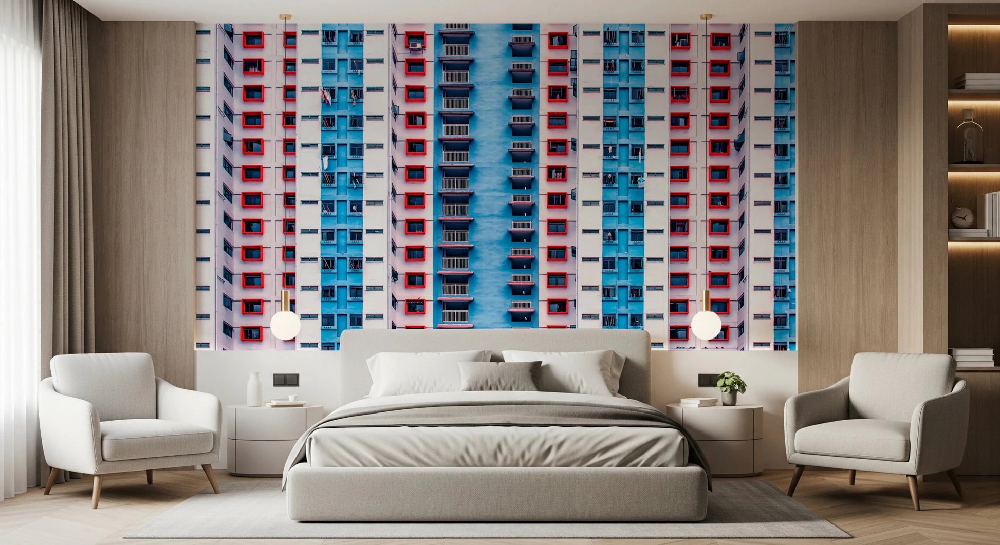 Urban Gridlock wallpaper mural of stacked red and blue windows behind a grey bed flanked by cream armchairs