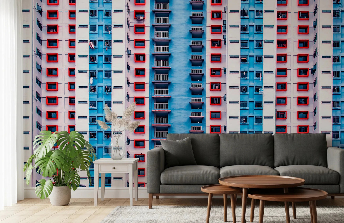 Urban Gridlock wallpaper mural of a colorful high-rise grid behind a grey sofa with a monstera plant