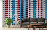 Urban Gridlock wallpaper mural of a colorful high-rise grid behind a grey sofa with a monstera plant