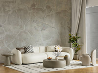 Urban Texture wallpaper mural in gray concrete behind a curved cream sofa and sage round coffee table