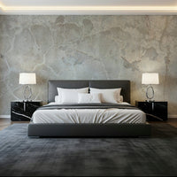 Urban Texture wallpaper mural in distressed gray concrete behind a dark leather bed and marble nightstands
