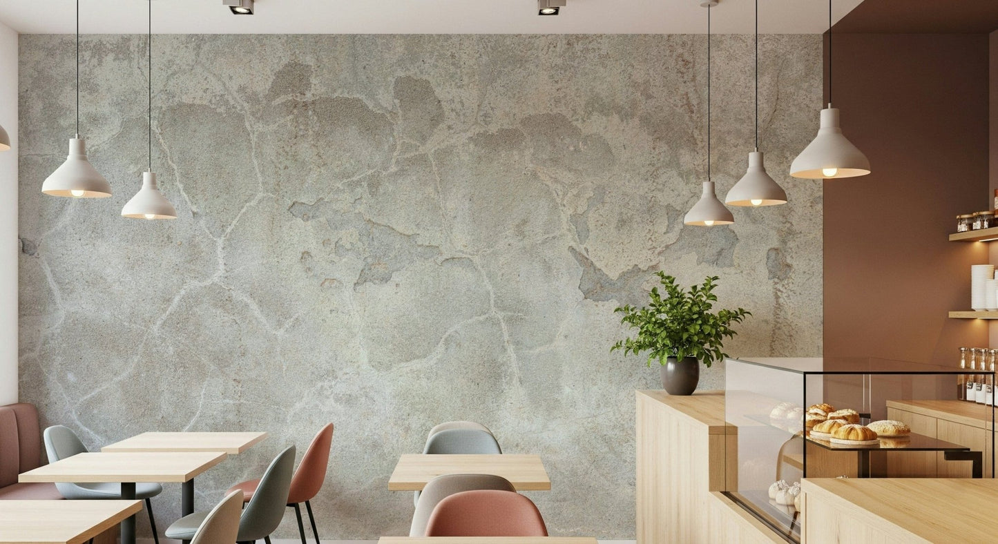 Urban Texture wallpaper mural in gray plaster behind wood cafe tables and a pastry case with white pendants