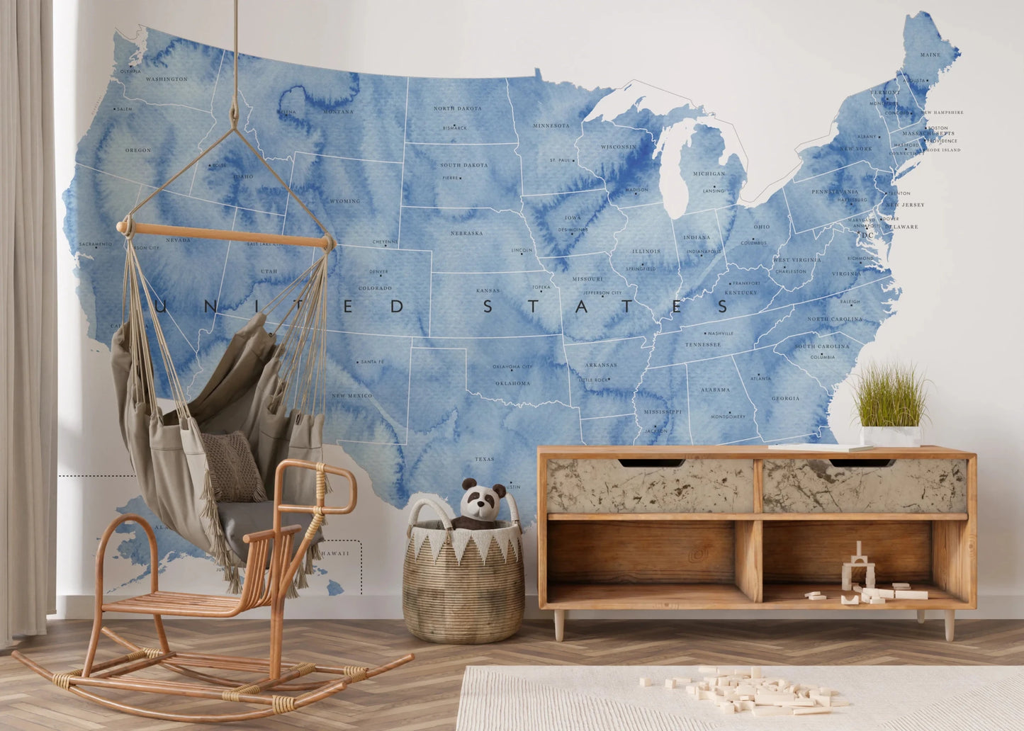 USA map with states and capitals in blue watercolor wallpaper mural in a kids room with a swing chair and credenza