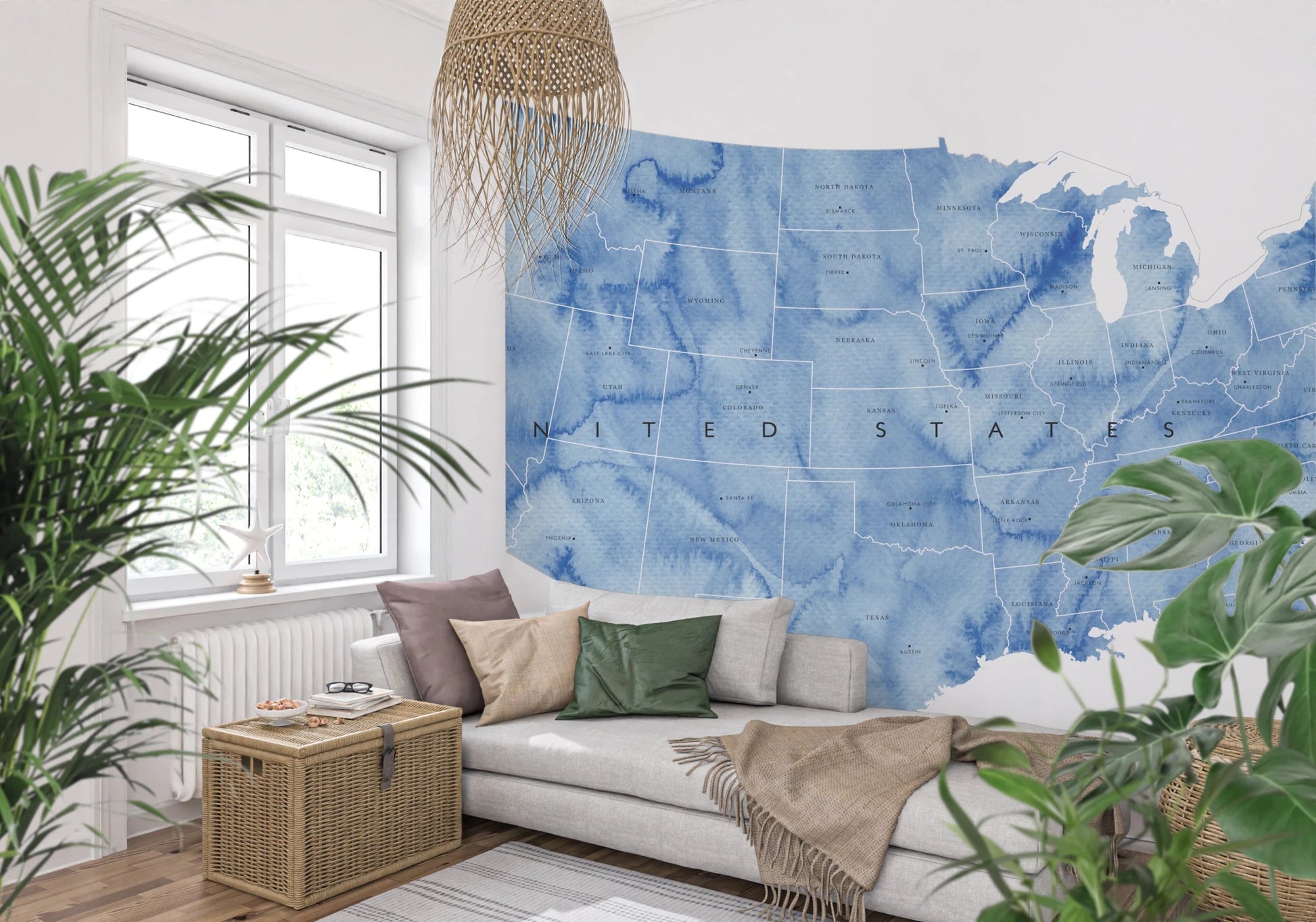 USA map with states and capitals in blue watercolor wallpaper mural behind a grey daybed with a rattan pendant