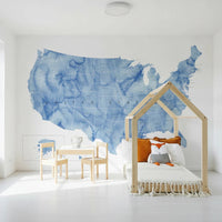 USA map with states and capitals in blue watercolor wallpaper mural in a kids room with a house-frame bed and fox toy