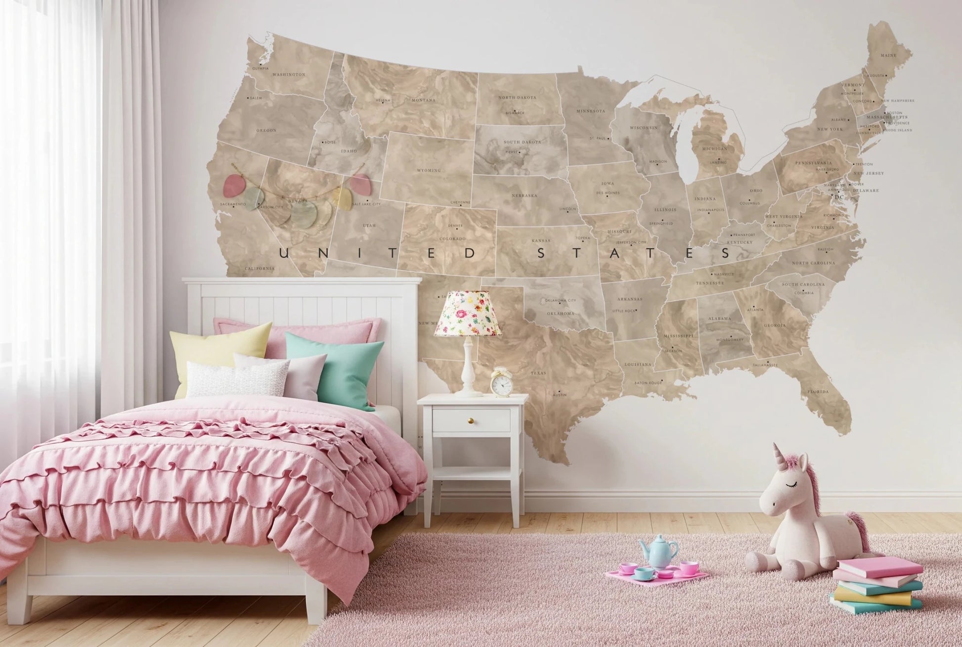 USA map with states and capitals in tan watercolor wallpaper mural above a pink ruffle bed in a girls bedroom