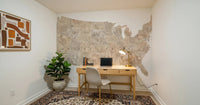 USA map with states and capitals in tan watercolor wallpaper mural in a home office above a wood desk and laptop