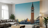 Venetian Sunrise wallpaper mural of St Mark's Campanile at sunrise above a grey sectional and wood coffee table