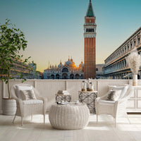 Venetian Sunrise wallpaper mural of the Venice square at sunrise behind white wicker chairs on a terrace