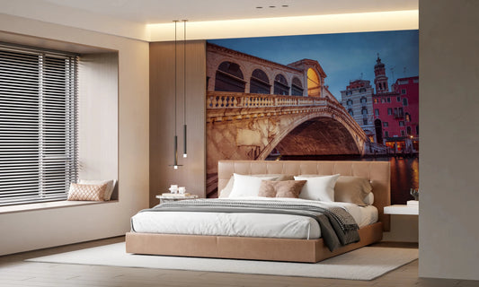 Venice at Dusk wall mural of the Rialto Bridge behind a tan upholstered bed with pendant lights