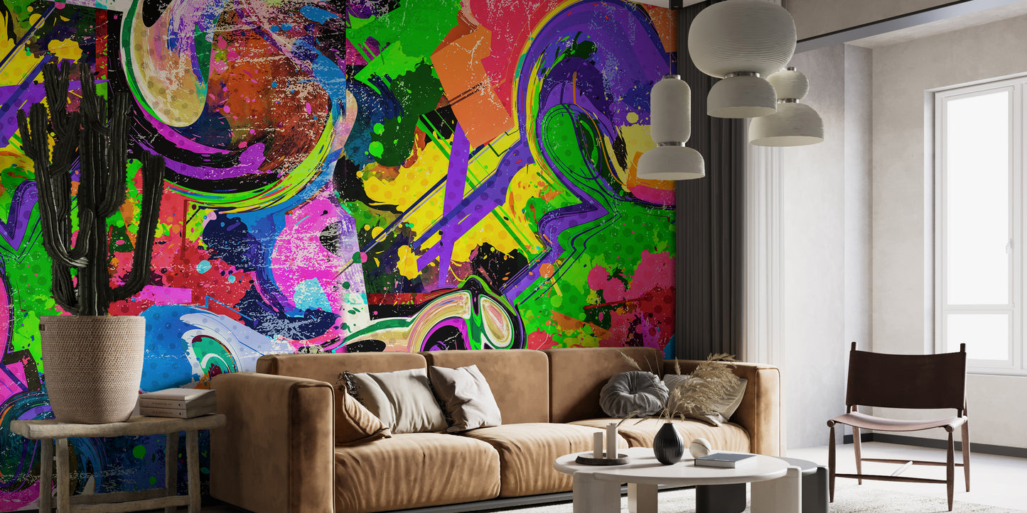 Vibrant Graffiti Splash wallpaper mural in bold rainbow colors behind a camel sofa with a cactus and pendant lights in a living room